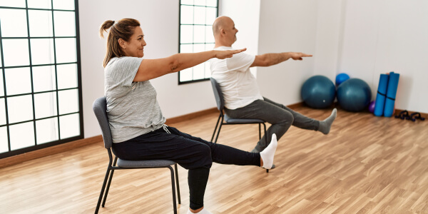 dame et monsieur sur une chaise qui font du yoga