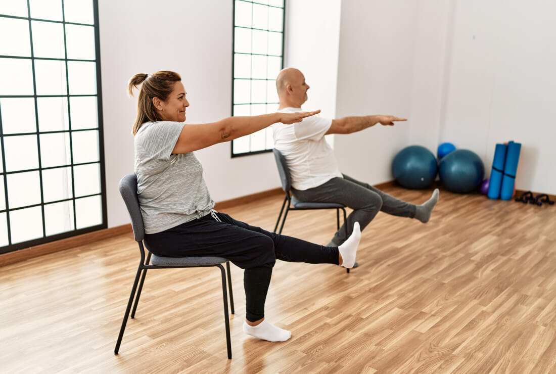 dame et monsieur sur une chaise qui font du yoga