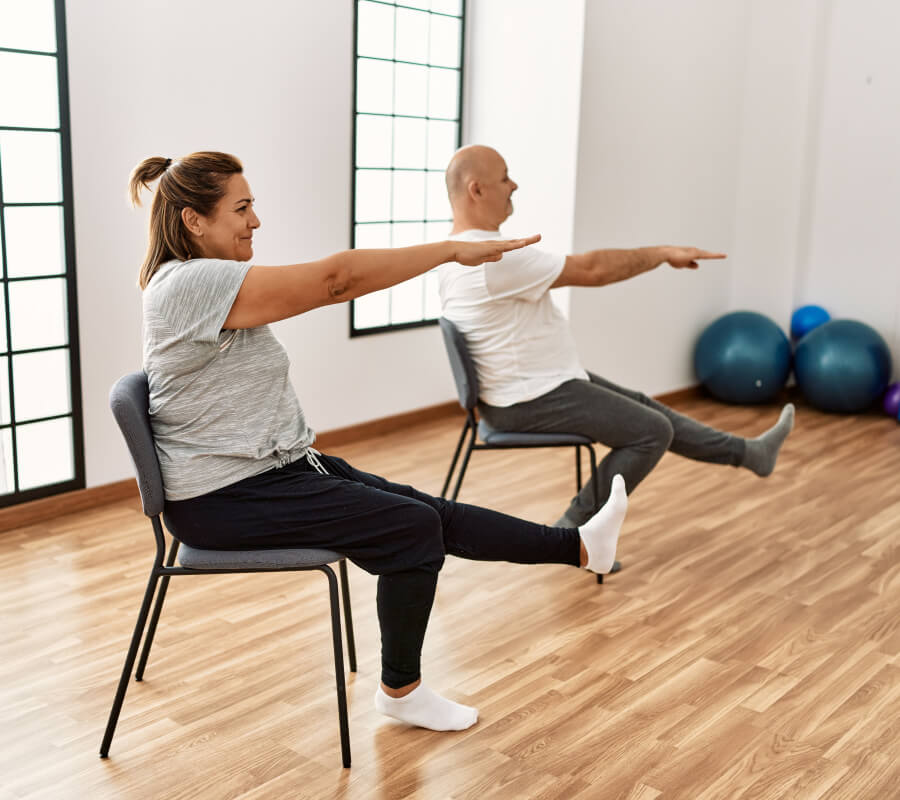 dame et monsieur sur une chaise qui font du yoga